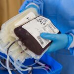 Visão de uma enfermeira com luvas segurando bolsas de sangue coletados no hospital