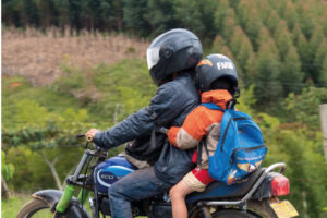 Motociclista que transporta criança