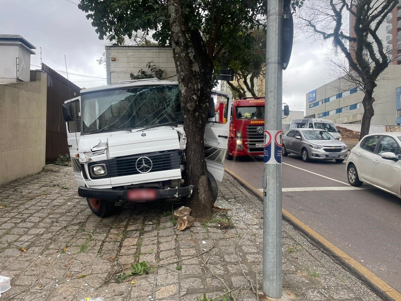 Motorista de caminhão bate contra árvore para desviar de pedestres e fica preso às ferragens em Curitiba