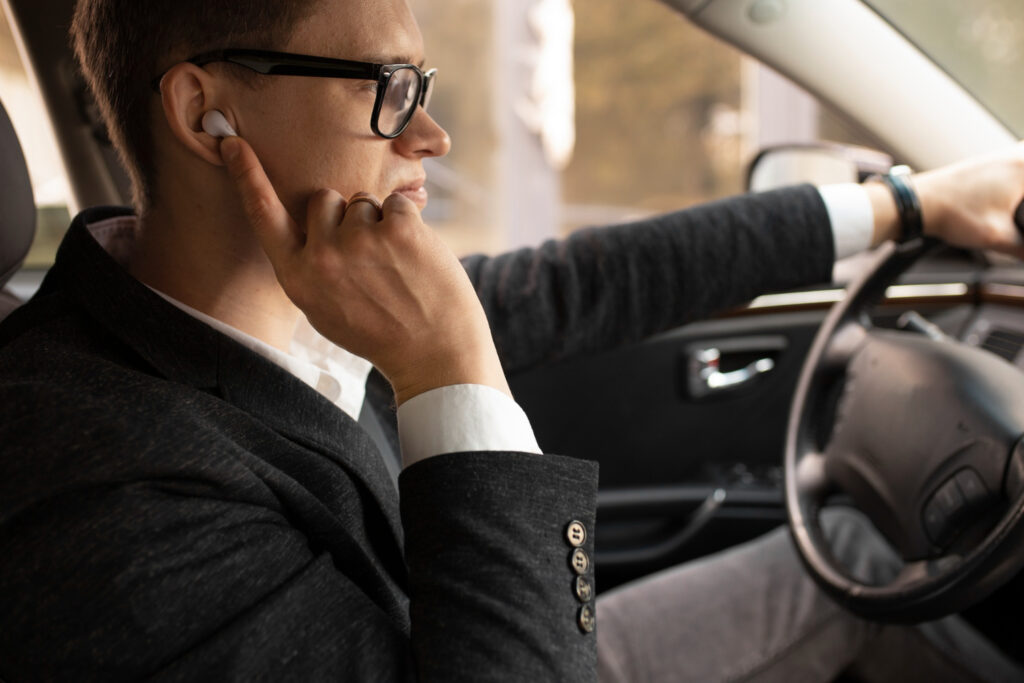 visão de um homem dirigindo um carro com um fone de ouvido