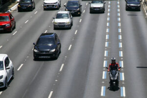 visão de uma rodovia com carros e moto na faixa azul