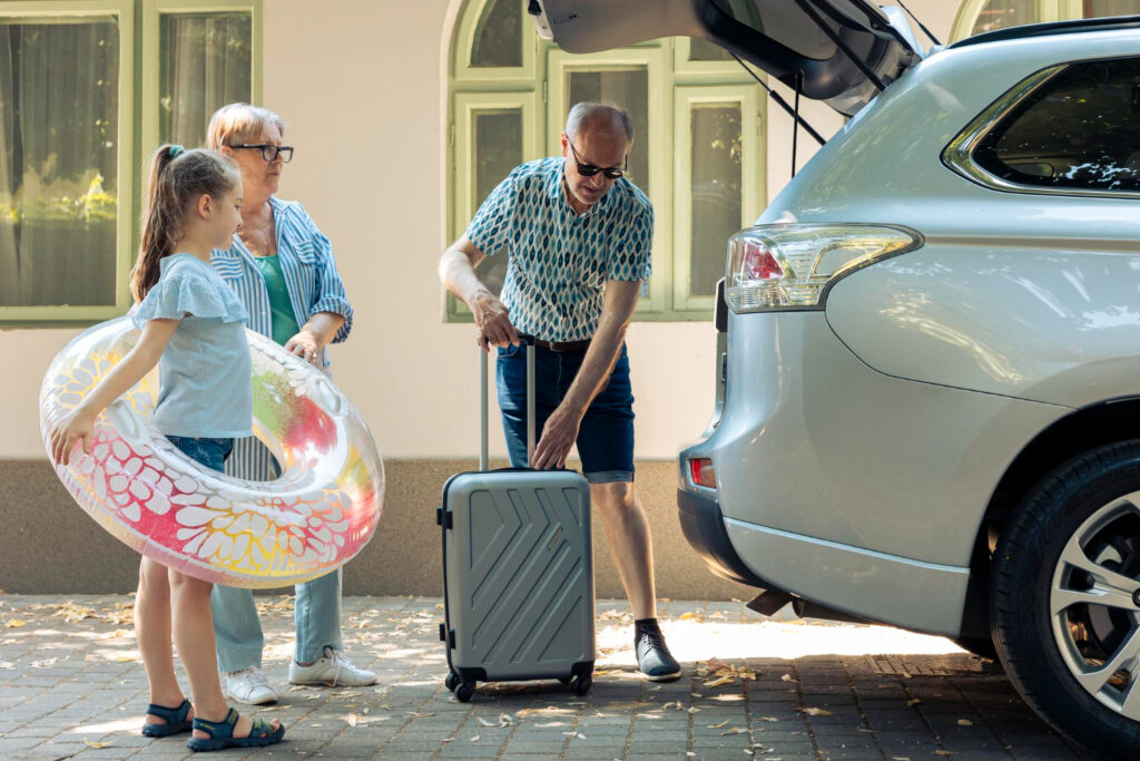 casal-de-idosos-e-sobrinha-carregando-bagagem-no-porta-malas-do-automovel