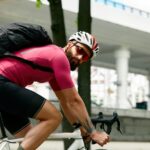 Ciclista com capacete e óculos de segurança olha por cima do ombro antes de fazer uma conversão