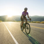 Mulher em bicicleta percorrendo a estrada.